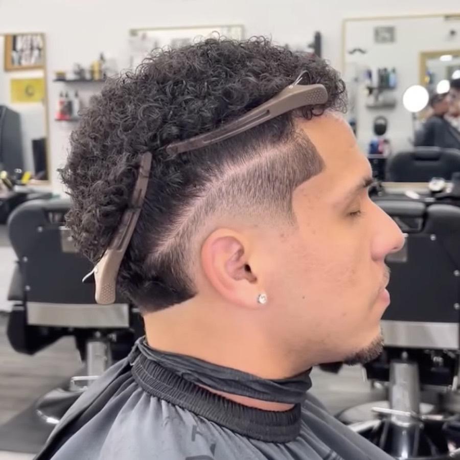 Curly top with a mid fade and hard part